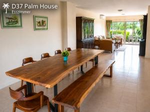 a wooden table and chairs in a living room at Oceanside Place in Rayong