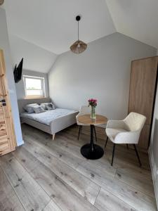 a bedroom with a bed and a table and chairs at Sunbella Sarbinowo in Sarbinowo