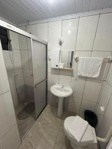 a bathroom with a shower and a toilet and a sink at Pousada Tia Leonor in Gramado