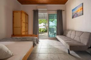 a living room with a bed and a couch at Studios Vagelis in Kalamitsi +148 photos