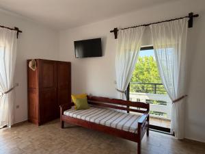 a room with a couch and a tv and a window at Zourpos Studios in Kalyves