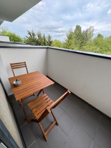 a wooden table and a chair on a balcony at Apartmán pod Rovencom in Nové Mesto nad Váhom