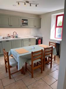 a kitchen with a table and some chairs and a table and a kitchen at Callacoon Cottage in Louisburgh
