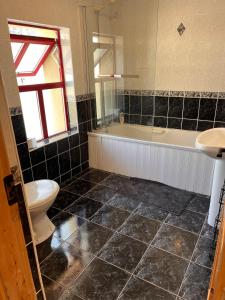 a bathroom with a toilet and a tub and a sink at Callacoon Cottage in Louisburgh +4 photos