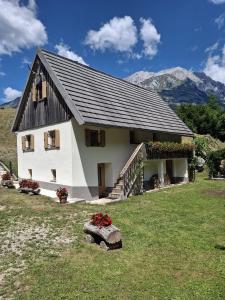a large white house with mountains in the background at Chalet Vrsnik Hideaway in Soča