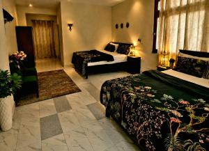 a large hotel room with two beds and a chair at Sukoon Hideout Kaghan Valley in Lahar Bānda