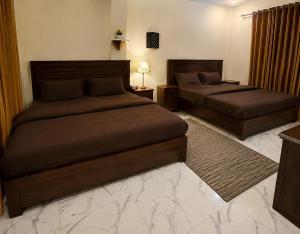 two beds in a hotel room withskirts at Sukoon Hideout Kaghan Valley in Lahar Bānda +14 photos