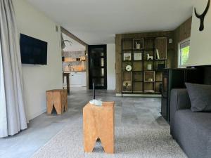 a living room with a couch and a table at Scandinavian Forest Cabin in Twente in Markelo