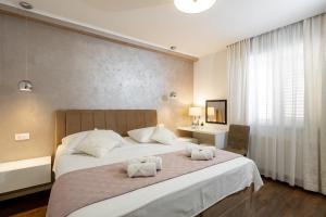 a bedroom with a large bed with towels on it at Island Breeze Oasis by Belmont Realty in Vela Luka