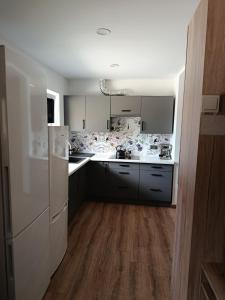 a kitchen with white appliances and wooden floors at Noclegi u Kozickich in Tomaszów Lubelski