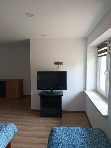 a living room with a flat screen tv on a table at Noclegi u Kozickich in Tomaszów Lubelski