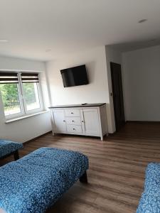 a bedroom with two beds and a tv on the wall at Noclegi u Kozickich in Tomaszów Lubelski +5 photos