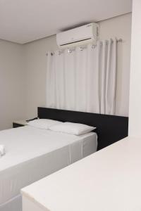 two beds in a room with white curtains at Hotel Macapaba in Macapá