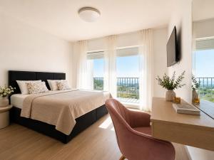a bedroom with a bed and a desk with a computer at Villa Cardellino in Klis