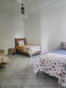 a room with two beds and a couch in it at F3 entre nature et calme in Raʼs al Jabal
