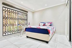 a bedroom with a bed and a large window at Magic garden in Vereeniging