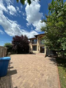 a house with a brick driveway in front of it at Vila La Cazemată Bucov in Satu Bucovei