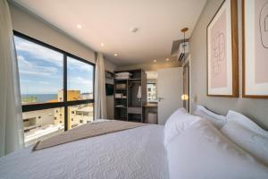 a bedroom with a bed and a large window at Villa Francione in Bombinhas +59 photos