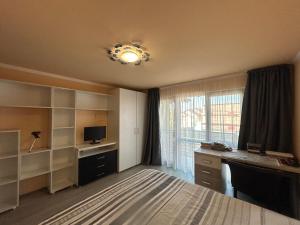 a room with a bedroom with a desk and a window at Vila La Cazemată Bucov in Satu Bucovei