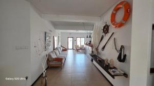 a living room with white walls and a long hallway at Residencial Raiar in Mindelo