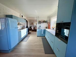 a blue kitchen with blue cabinets and appliances at Fornes Bed & Breakfast in Fornes