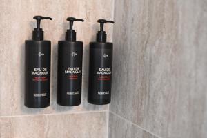 three black bottles on a wall in a bathroom at Hotel Local 101 Beaurepaire in Paris +21 photos