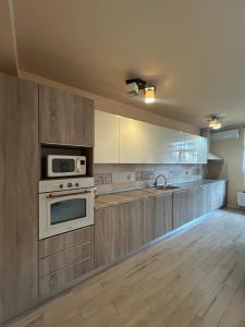 a kitchen with a stove and a microwave at Vila La Cazemată Bucov in Satu Bucovei