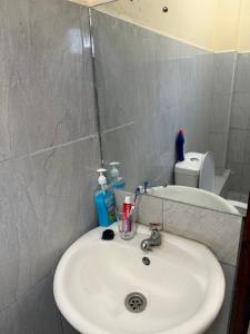 a bathroom with a white sink and a toilet at Arabella Homes in Maralal
