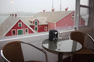 a table and chairs in front of a window with a red barn at Rum Runner Inn in Lunenburg