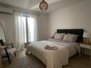 a bedroom with a bed and a chair and a window at La villa des Carriers - maison avec piscine, 10 min mer in Roquefort-les-Pins +53 photos