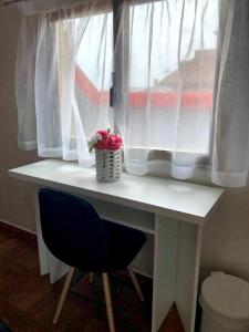 a white desk with a window with a blue chair at Via Gagliardi - Centro in Vibo Valentia +12 photos