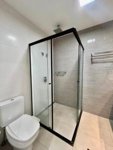 a bathroom with a toilet and a glass shower at Vista Ampla e Estilo Industrial nesse Lindo Loft in Campo Grande +6 photos