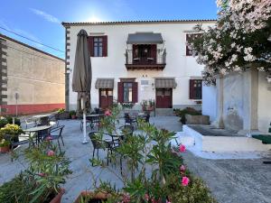 a patio with tables and chairs and a building at Archontiko Tsikari in Város