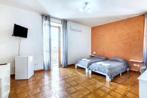 a bedroom with two beds and a television in a room at Via Gagliardi - Centro in Vibo Valentia