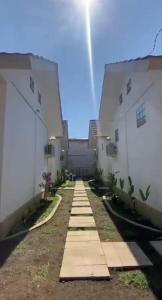 a pathway between two buildings with the sky in the background at Datang Kemari Bungalow in Gili Islands