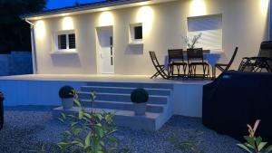 a white house with a table and chairs in front of it at Maison neuve in Berson