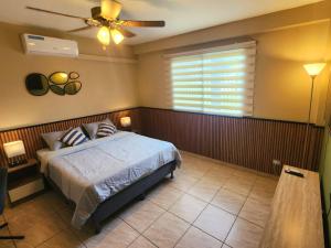 a bedroom with a bed and a ceiling fan at Coconut Lodge in Panama City