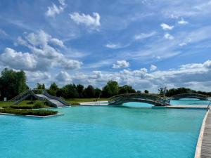a large pool of blue water with a bridge at Maison le Village - Maison d’Hôtes in Montagny-lès-Beaune