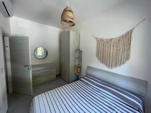 una camera da letto con un letto, una finestra e uno specchio di Appartamento Il Garofano a Quercianella