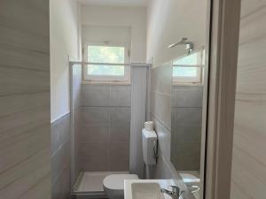 un bagno con WC, lavandino e doccia di Appartamento Il Garofano a Quercianella Altre 32 foto