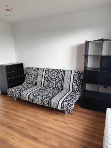 a couch sitting in a living room next to a wall at Apartman Elizabeth in Pardubice