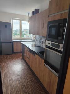 a kitchen with a microwave and a stove top oven at Apartman Elizabeth in Pardubice