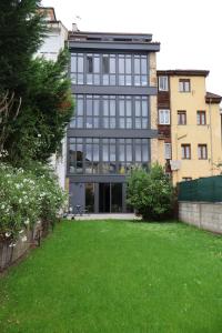 a large building with glass windows and a green yard at MoV Flexliving in Oviedo