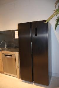 a stainless steel refrigerator in a kitchen at MoV Flexliving in Oviedo +9 photos