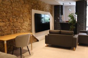 a living room with a table and chairs and a stone wall at MoV Flexliving in Oviedo