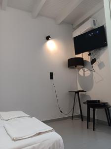 a white room with a bed and a flat screen tv at Fortezzino in Rethymno