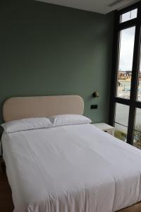a bedroom with a large white bed and a window at MoV Flexliving in Oviedo