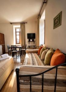 a bedroom with two beds and a living room with a table at Archontiko Tsikari in Város