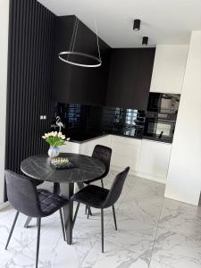 a dining room with a black table and chairs at Apart Premium Ku Morzu in Sianozety