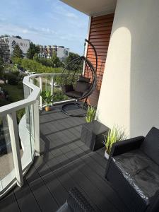 a patio with a chair and a swing on a balcony at Apart Premium Ku Morzu in Sianozety